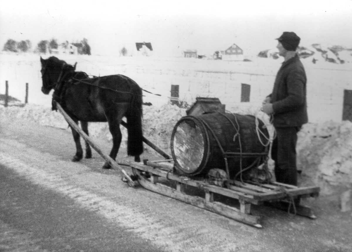 Ole og hesten Maia kjører vatn under ei vassløysa i 1966